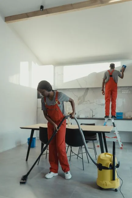 Person using spray bottle and cloth for cleaning a kitchen shelf, ensuring hygiene and cleanliness.